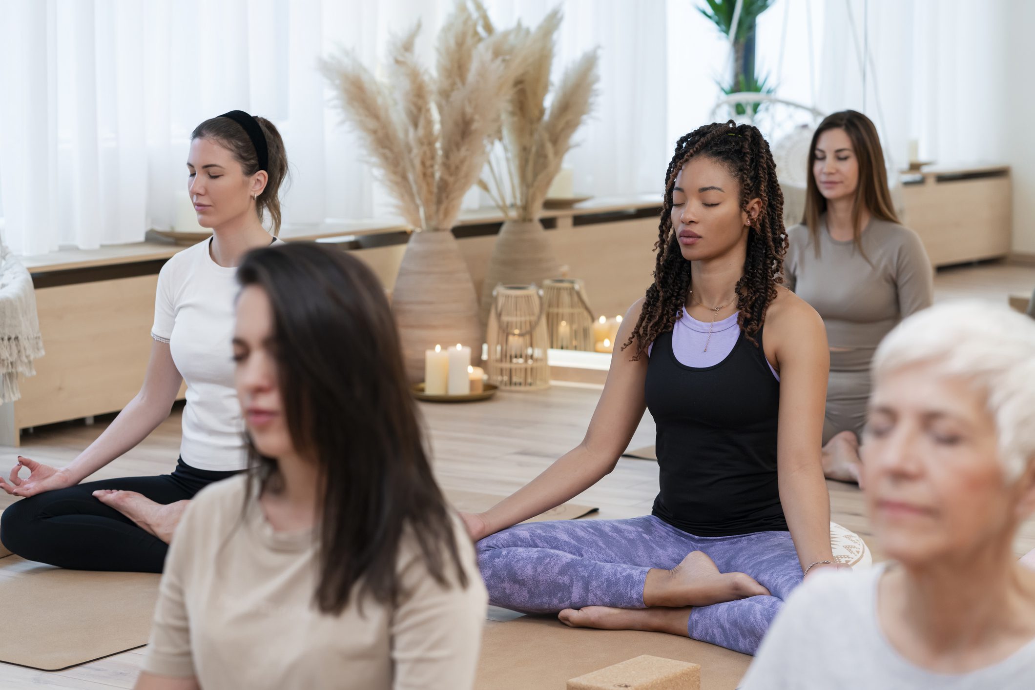 Five women sit together in a yoga class session.
